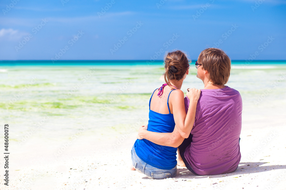 beautiful young couple sitting and having fun on beach beautiful young couple sitting and having fun on beach