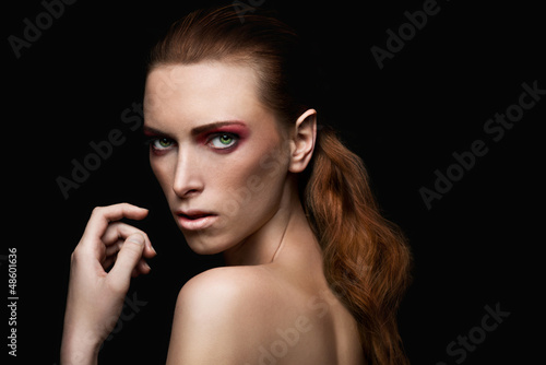 elegant red haired woman with healthy hair and red make up