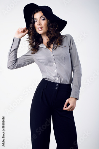Beautiful young woman wearing black hat, stripes shirt