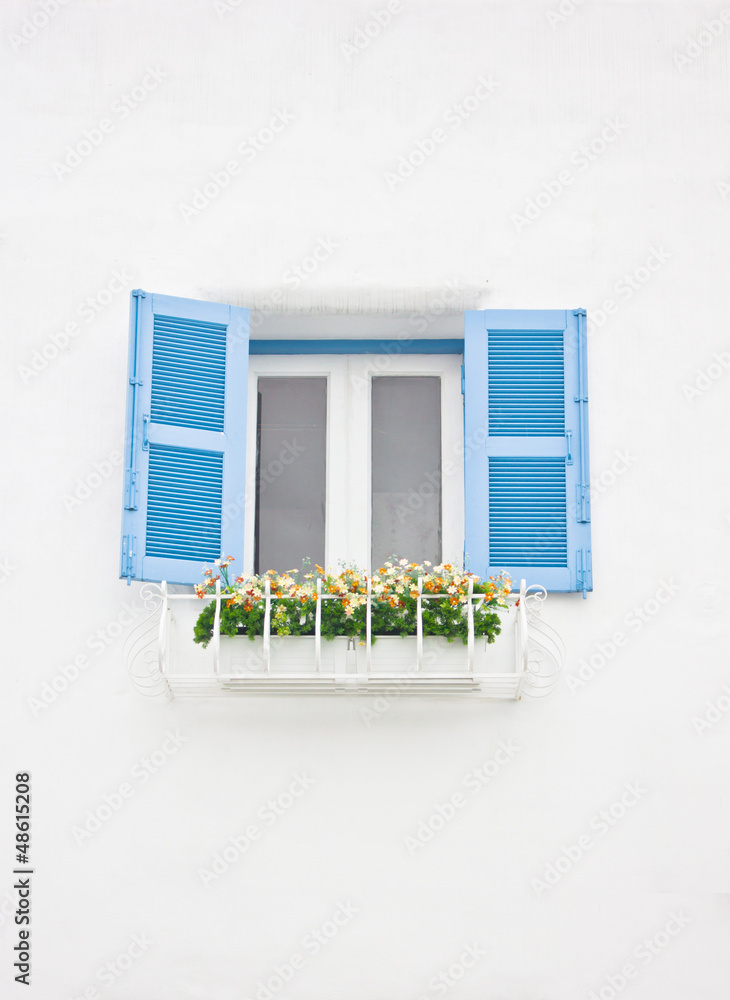 Fototapeta premium Blue open window with flowers ornament.