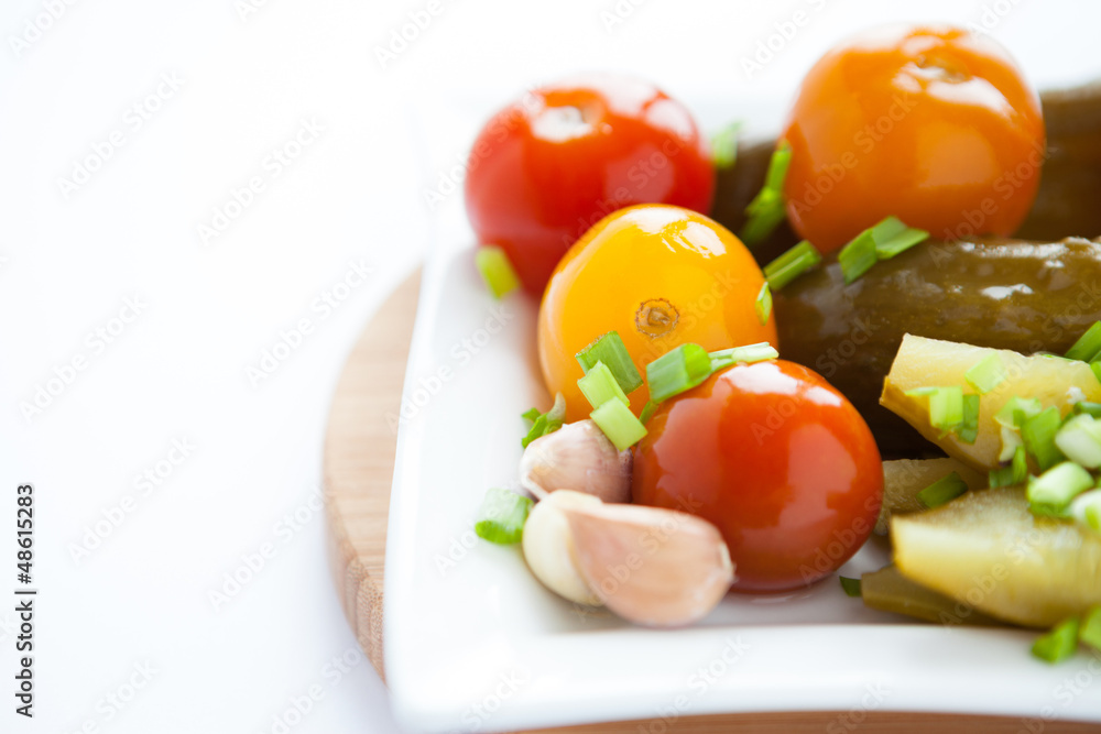 pickled vegetables on a white square plate pickled vegetables on a white square plate