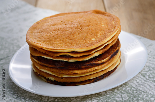 White plate with pankakes stack on the kitchen table