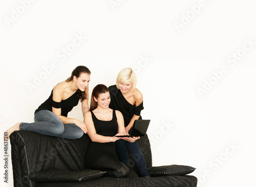 drei Mädels chillen mit Laptop auf dem Sofa