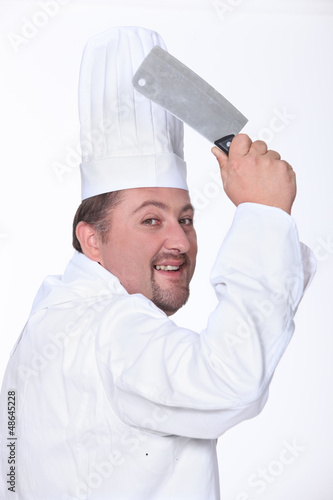 Chef in uniform wielding a cleaver
