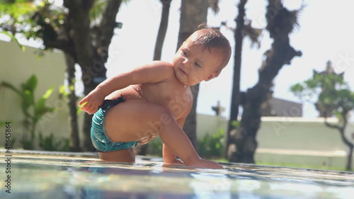 Adorable small girl playing near swimming pool