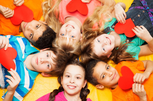 Kids laying in circle with hearts in their hands