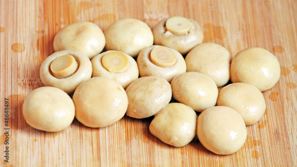 Whole champignon mushrooms on the chopping board Whole champignon mushrooms on the chopping board