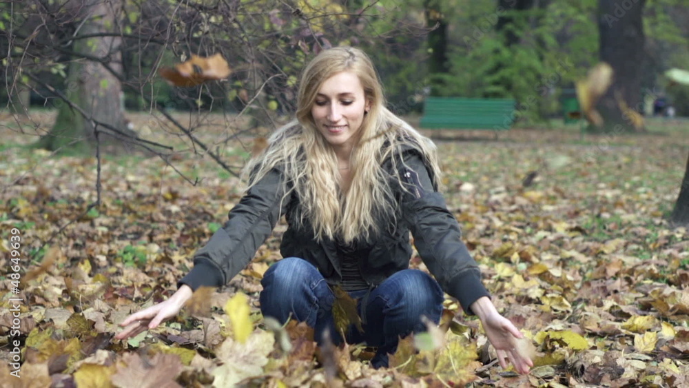 Woman throwing golden leaves in autumn park Woman throwing golden leaves in autumn park