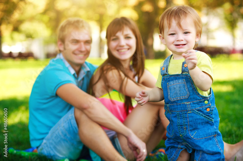 smiling baby with parents in a beautiful summer park