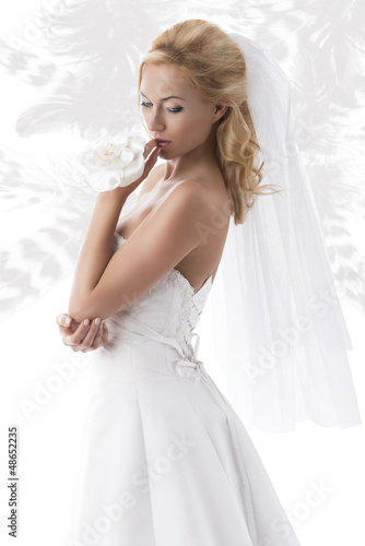 pretty blonde bride looks down at left