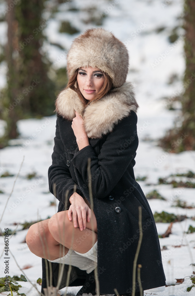 Sexy beautiful brunette girl in winter clothes in park