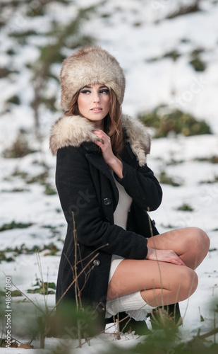 Sexy beautiful brunette girl in winter clothes in park