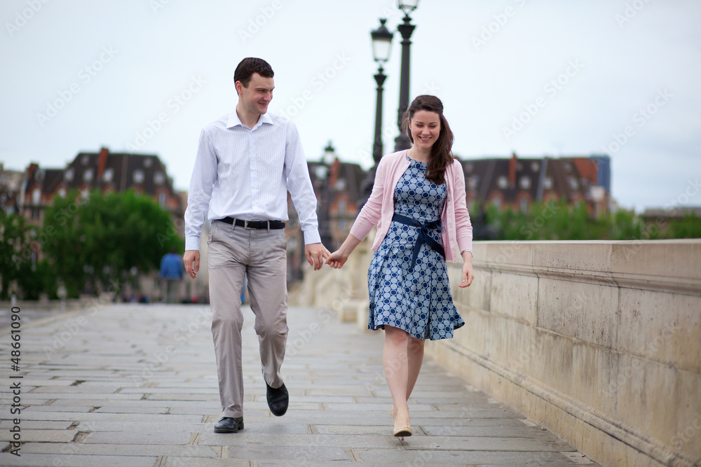Positive dating couple in Paris walking hand in hand
