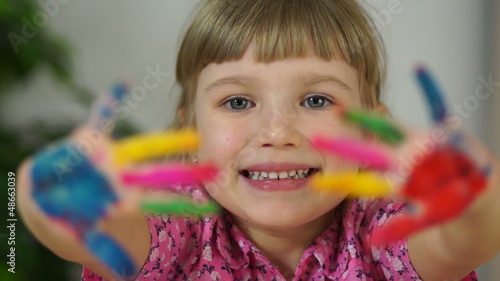 Laughing child. Hands in the paint. Baby covered in paint