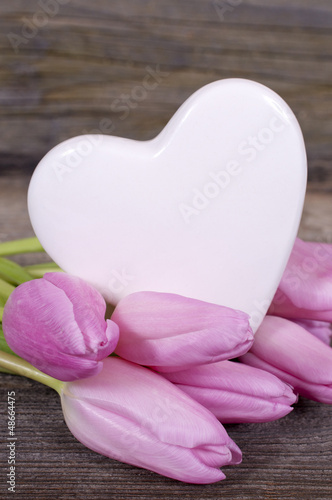Herz mit rosa Tulpen auf Holz