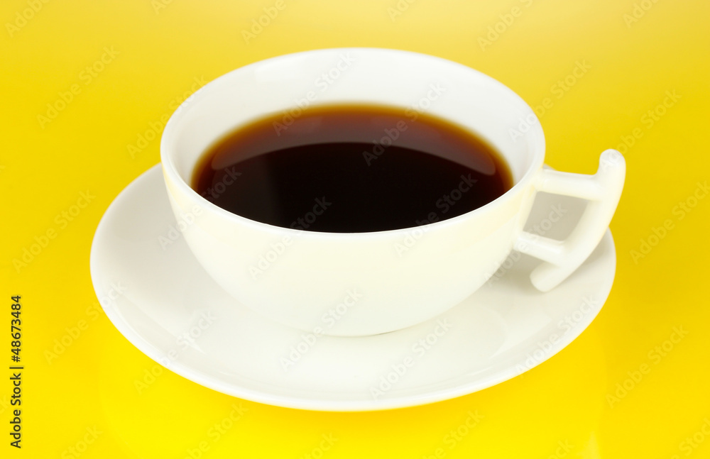 A cup of strong coffee on yellow background