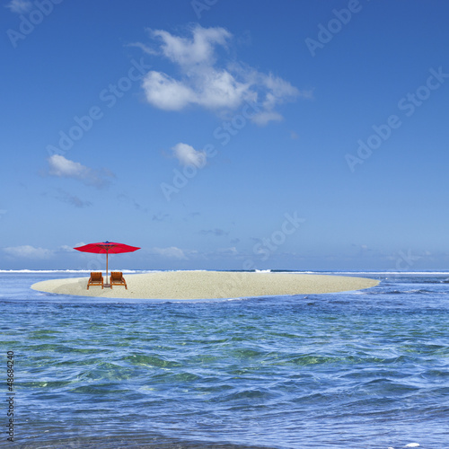 parasol rouge sur îlot de sable blanc