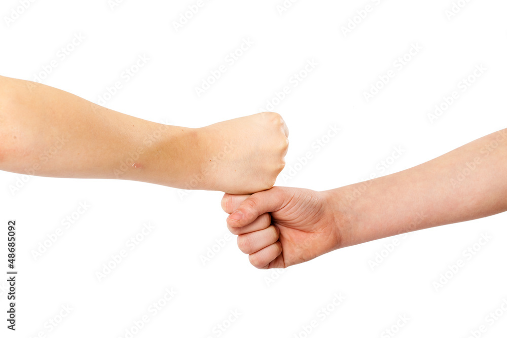 Two kids' fists lying on each other, isolated white Two kids' fists lying on each other, isolated white