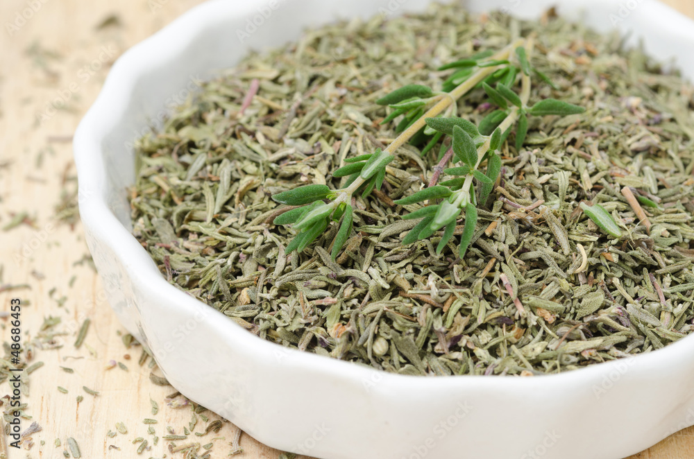 Dried and fresh thyme in a white bowl, selective focus, closeup