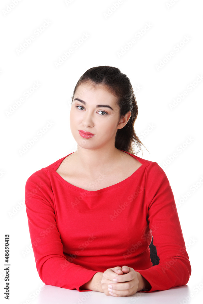Young woman in casual clothes sitting at the desk Young woman in casual clothes sitting at the desk