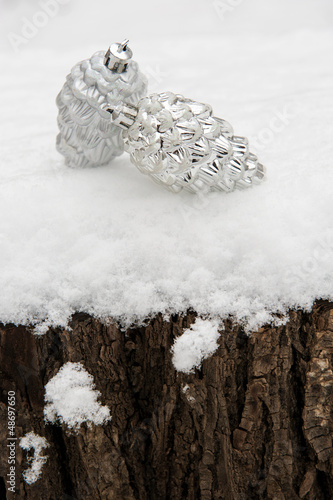 two toy cones on a tree stump in snow