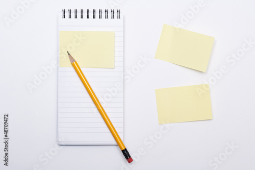 Notebook with yellow pencil on white background