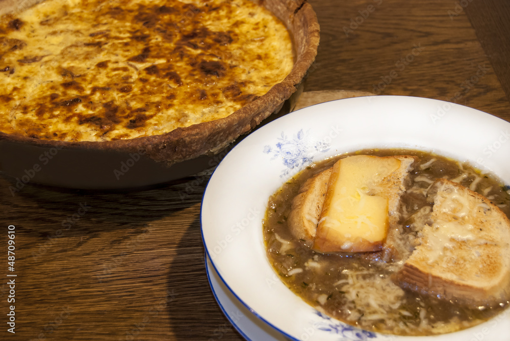 Homemade onion soup plate and quiche pie closeup