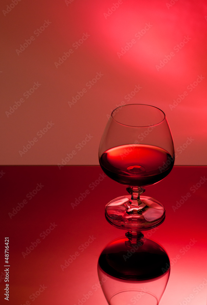 Ein Glas mit Alkohol vor rotem Hintergrund Ein Glas mit Alkohol vor rotem Hintergrund