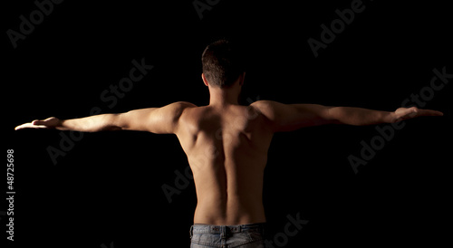 Shirtless young man with arms outstretched