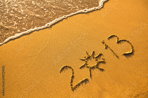 2013 written in sand on beach texture (soft wave of the sea)