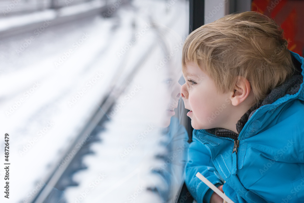 Cute little boy looking out train window Cute little boy looking out train window