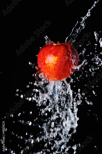 Red apple water splash on black background