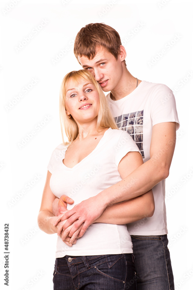Happy smiling young couple standing together hugging Happy smiling young couple standing together hugging