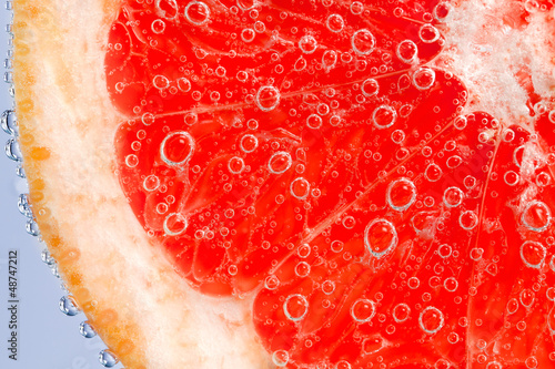 Fresh grapefruit in water with bubbles