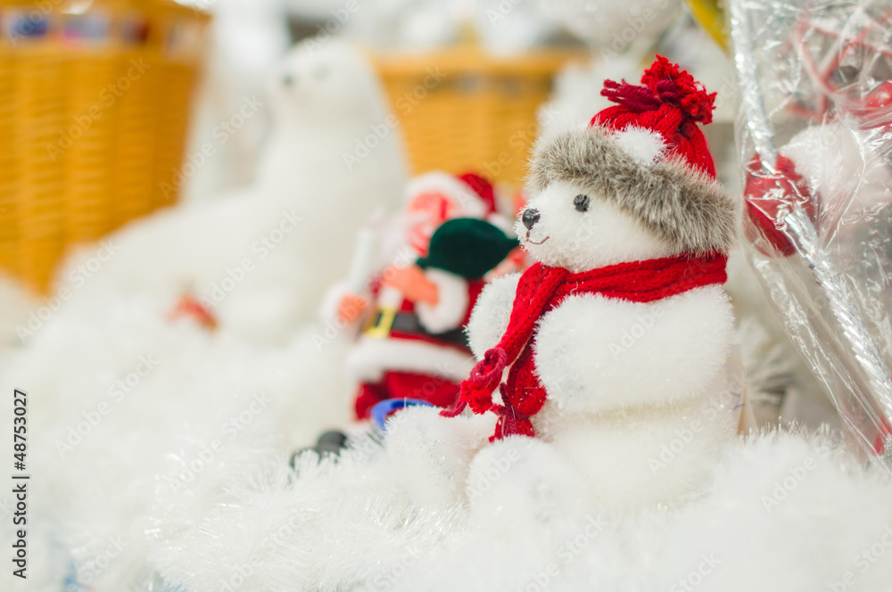 Toy polar bear in hat and Santa on back under christmas tree in