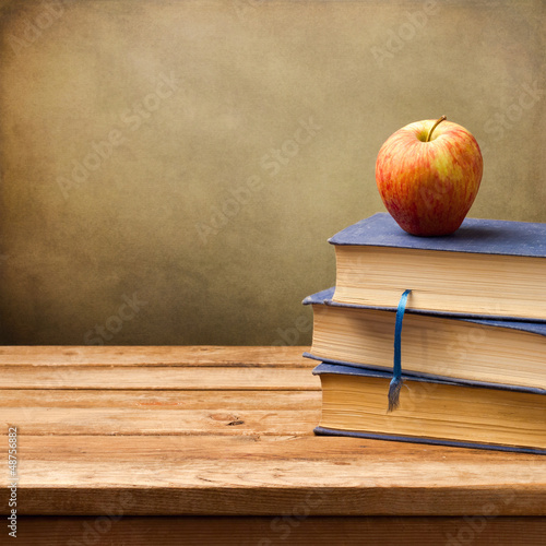 Background with vintage books and apple.