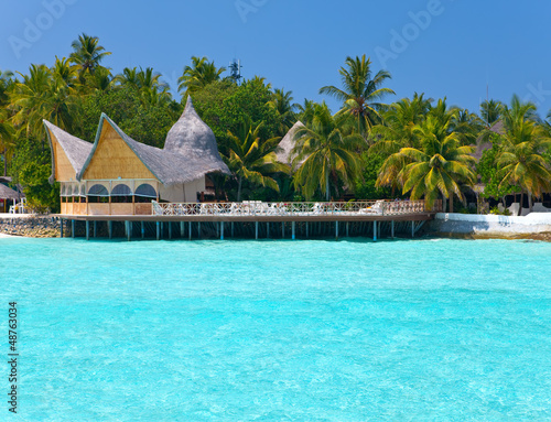 Maldives. A sandy beach, houses and an ocean coast