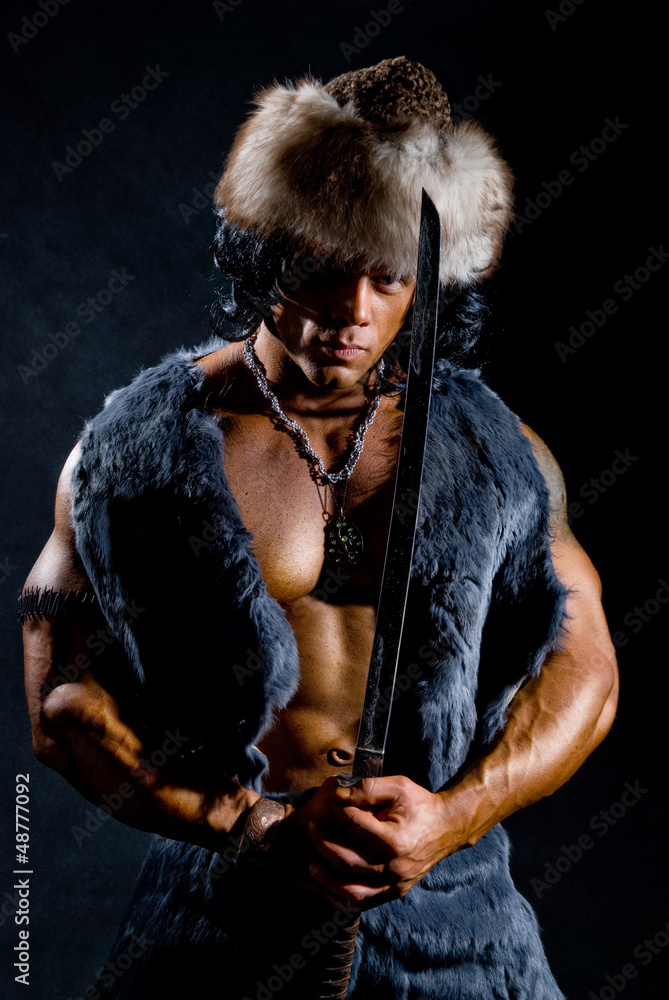 Fototapeta premium Male warrior with a sword in the form of a barbarian