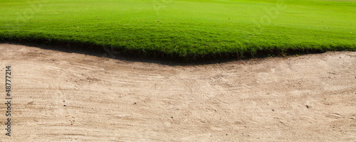 Fotografie Sand bunker on the golf course with green grass