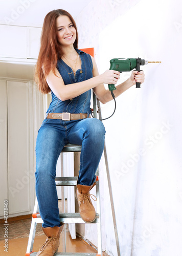 woman makes repairs in home photo