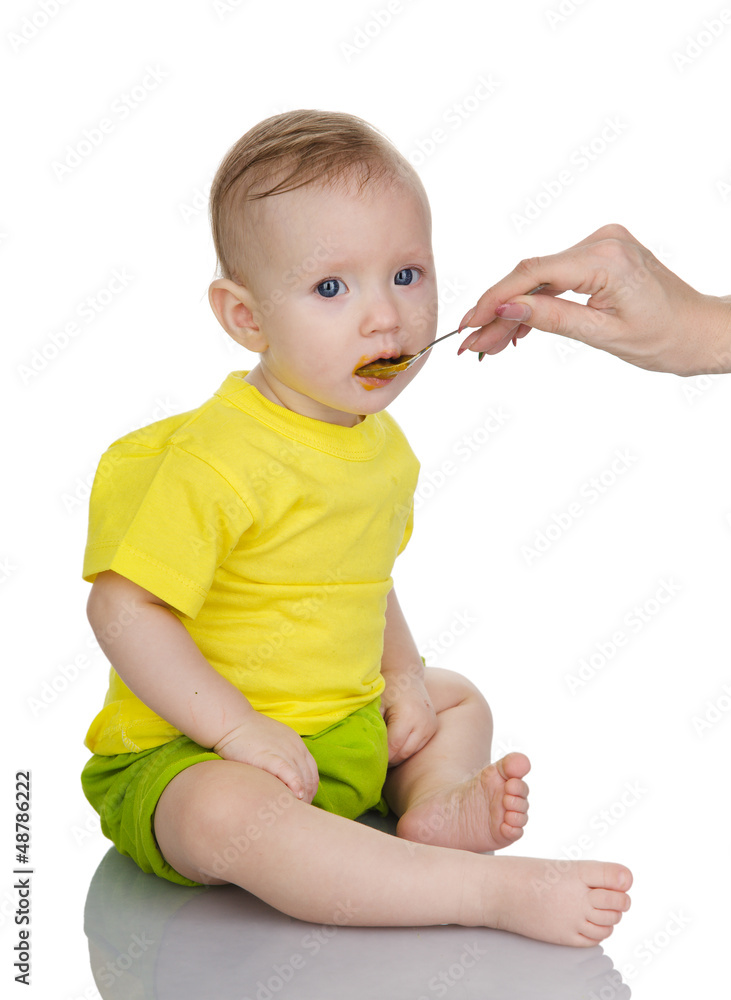 baby girl eating baby food with spoon. isolated on white baby girl eating baby food with spoon. isolated on white