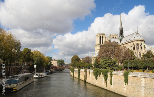 Notre Dame of Paris and Sine river with a cloudy blue sky