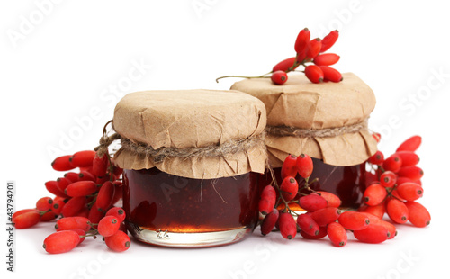 ripe barberries and jars of jam isolated white
