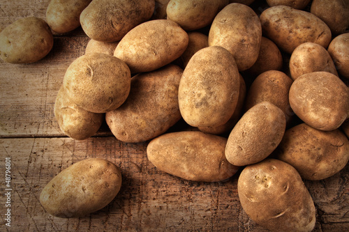 Fresh potatoes on wooden background