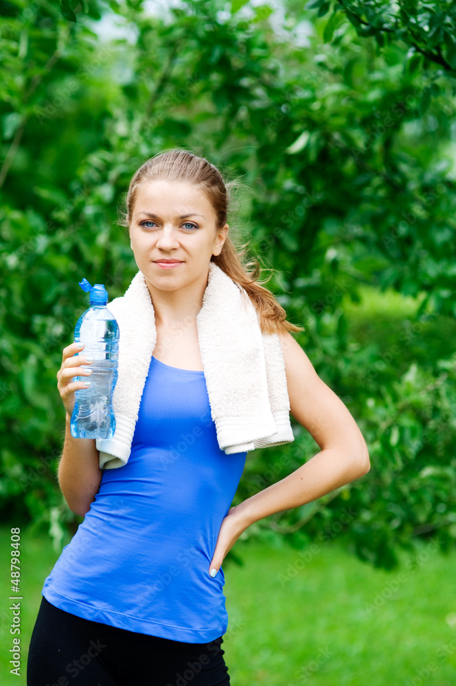 Smiling woman with water bottle after workout Smiling woman with water bottle after workout