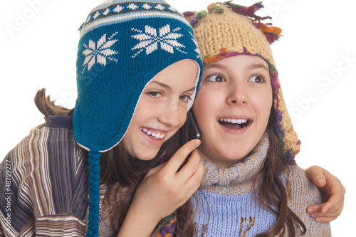 Beautiful young girls in warm winter clothes speaking on a mobil