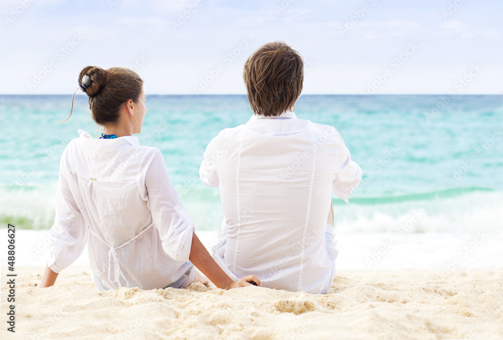 back view of happy couple on tropical beach. honeymoon concept