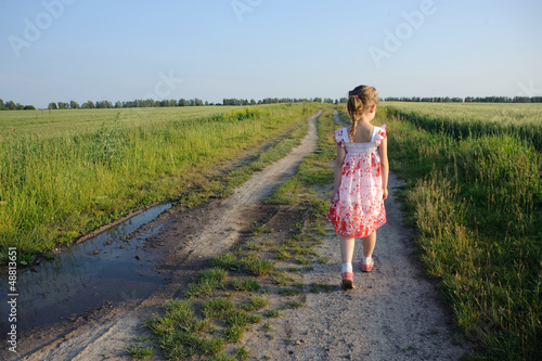 little girl walking on the road