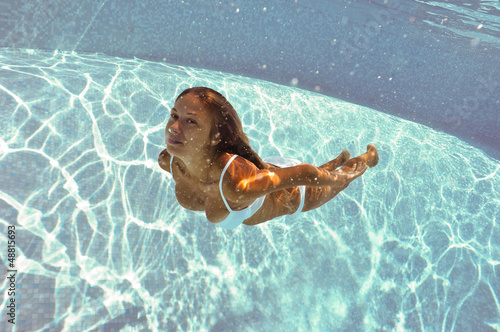 Girl portrait posing underwater with white bikini.
