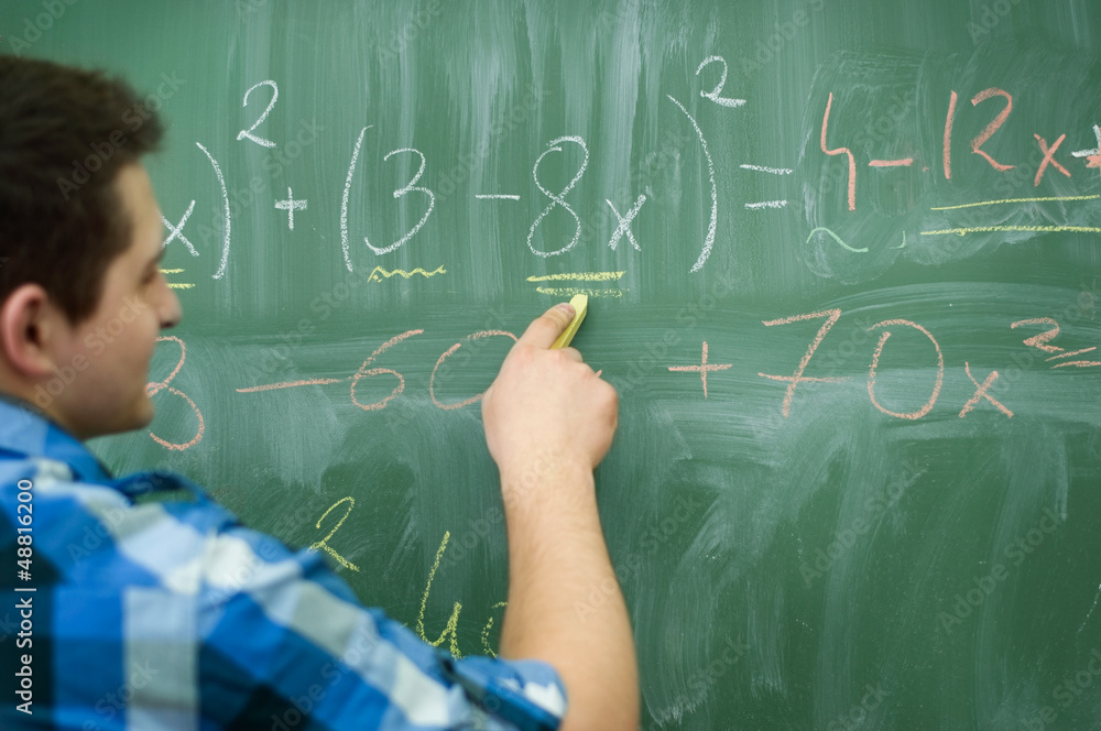 Student boy writing mathematical formula Student boy writing mathematical formula